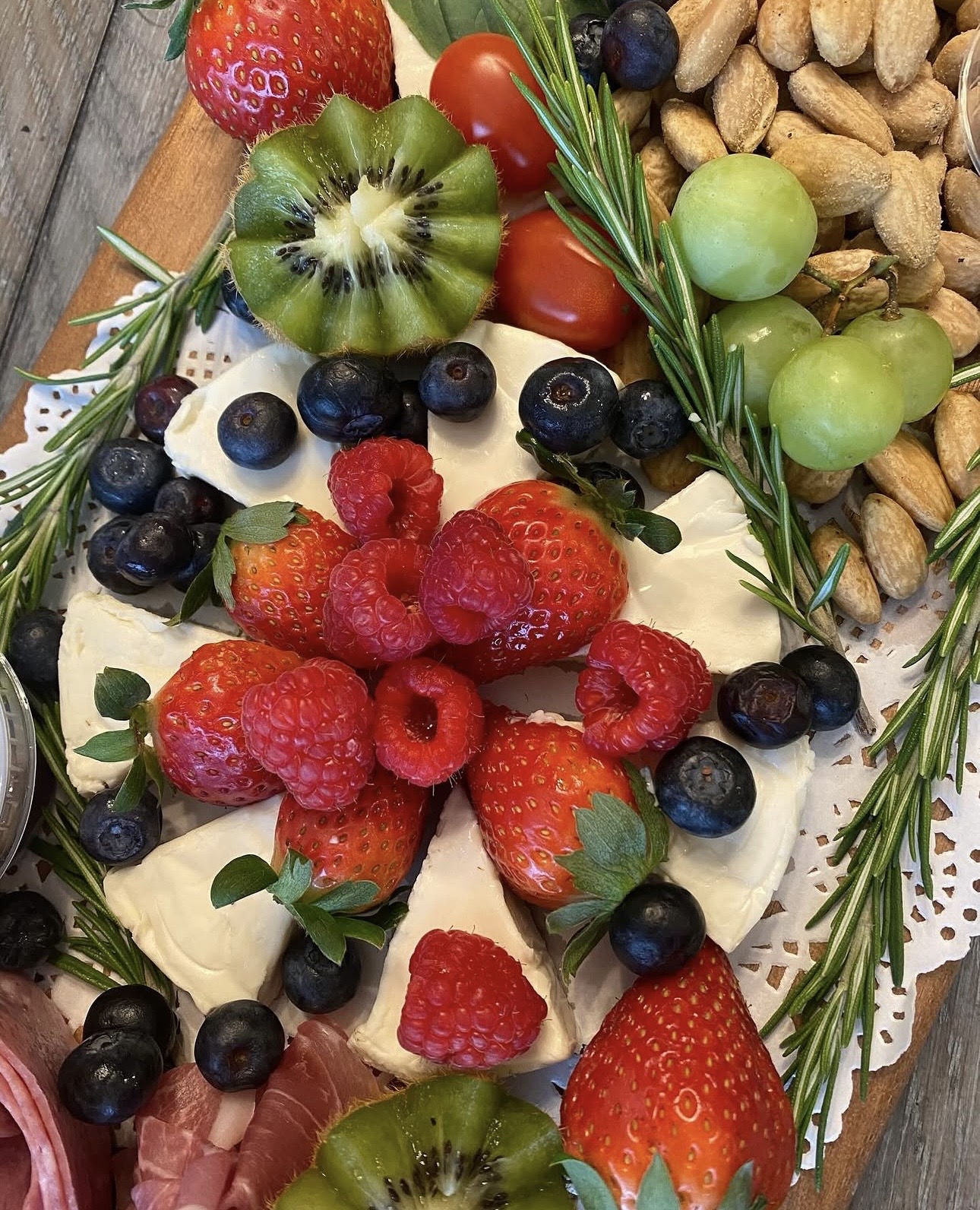 Beautiful brie and fresh berry board with rosemary